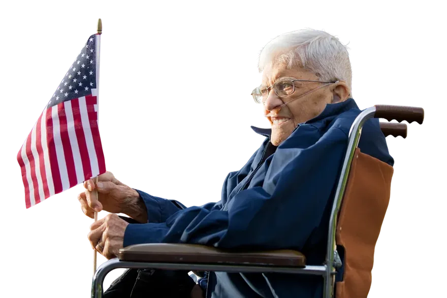 Elderly veteran in a wheelchair holding an American flag